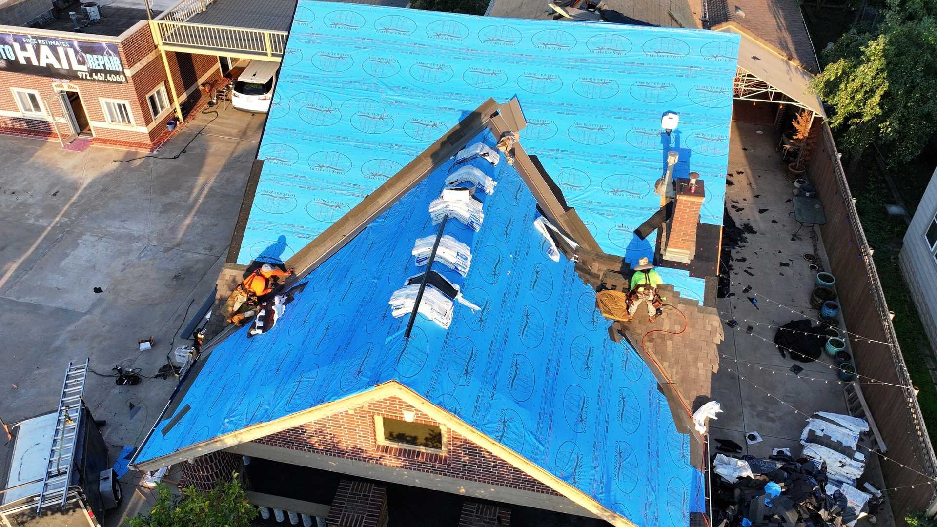 Aerial drone view of a DFW-area roof being worked on by Global Roofing Pros